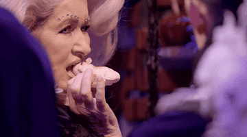 GIF of a woman eating cake in the shape of a rat