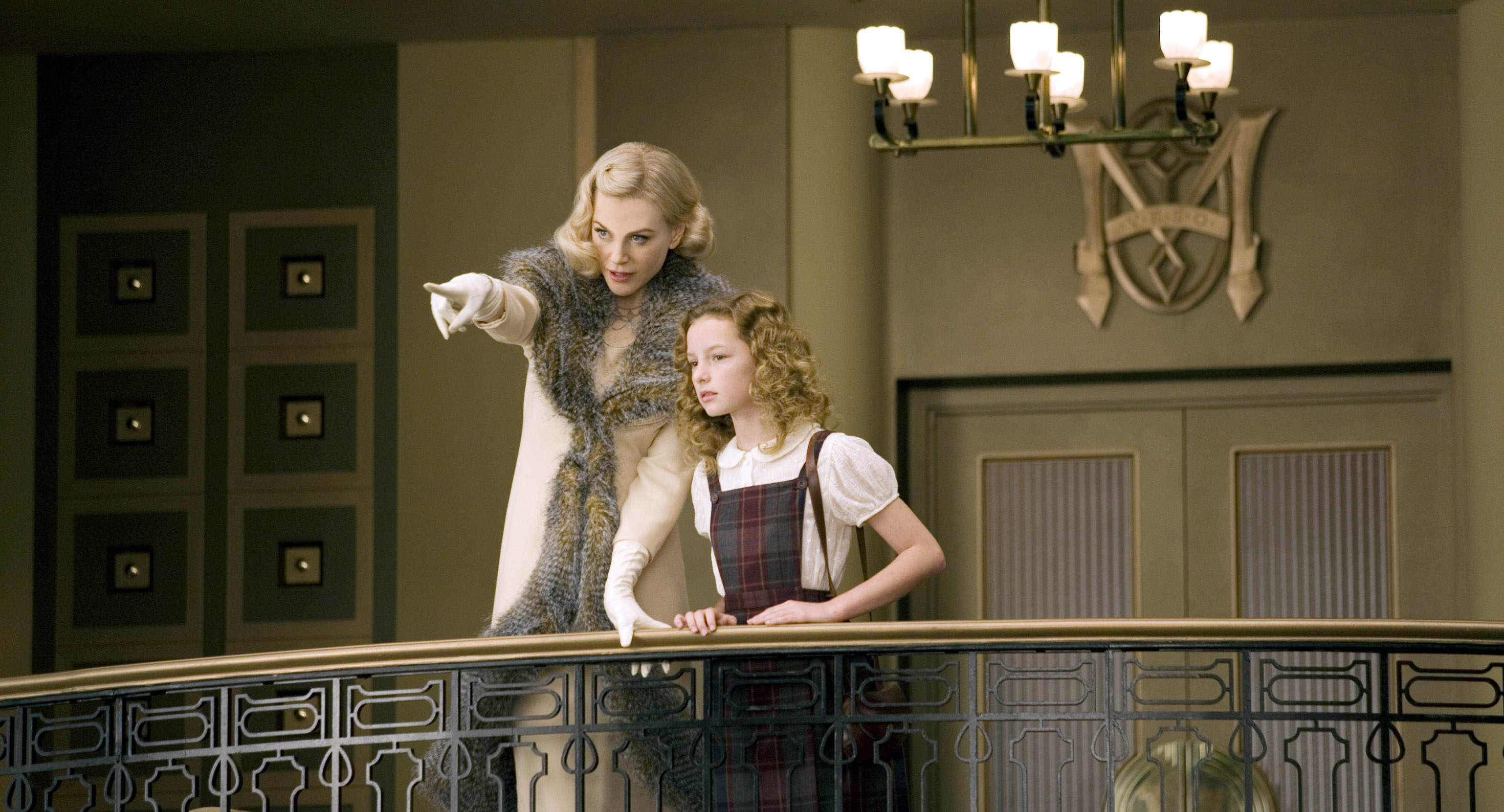 Nicole Kidman points out something to Lyra