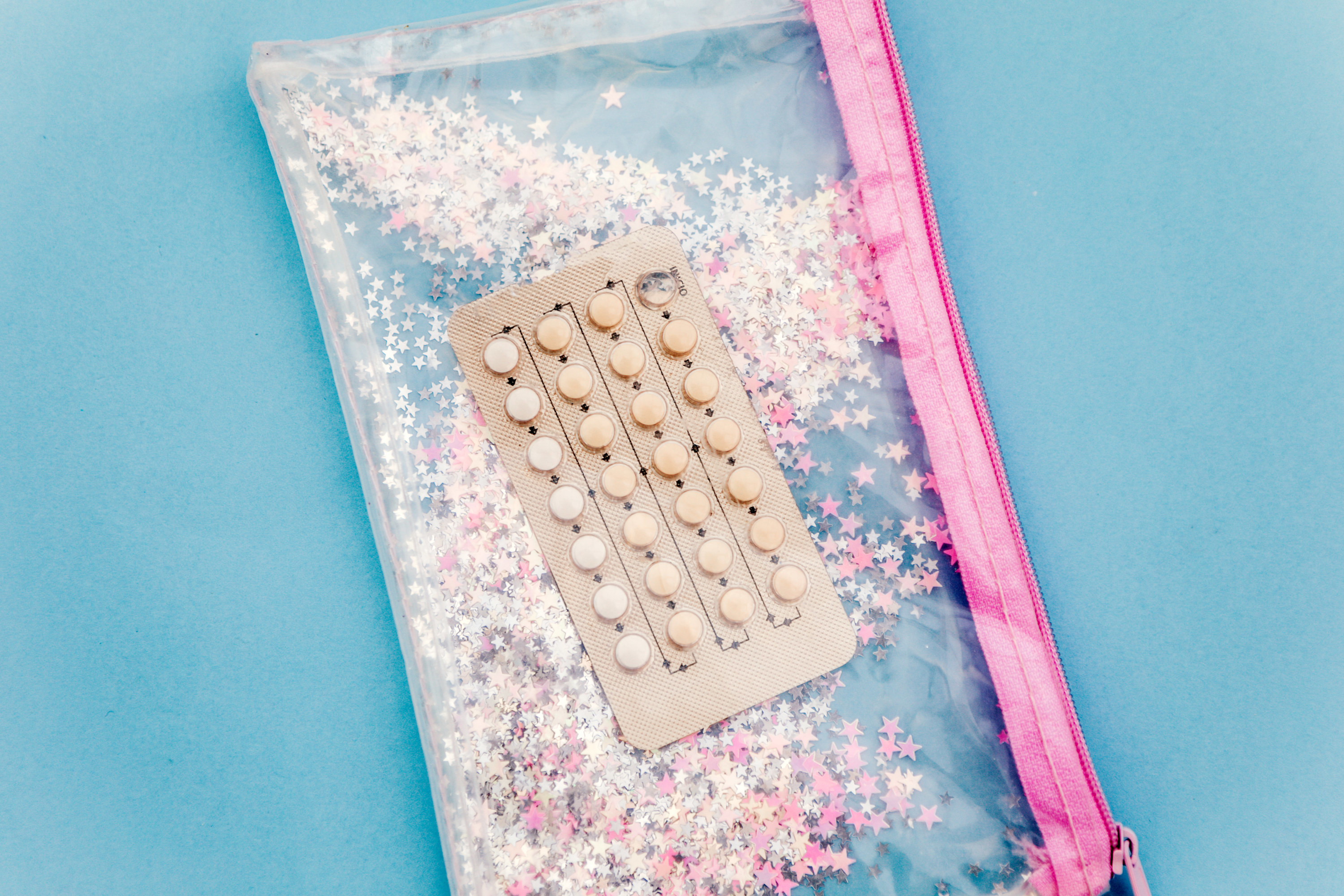 A package of birth control pills sit on a sparkly pencil case