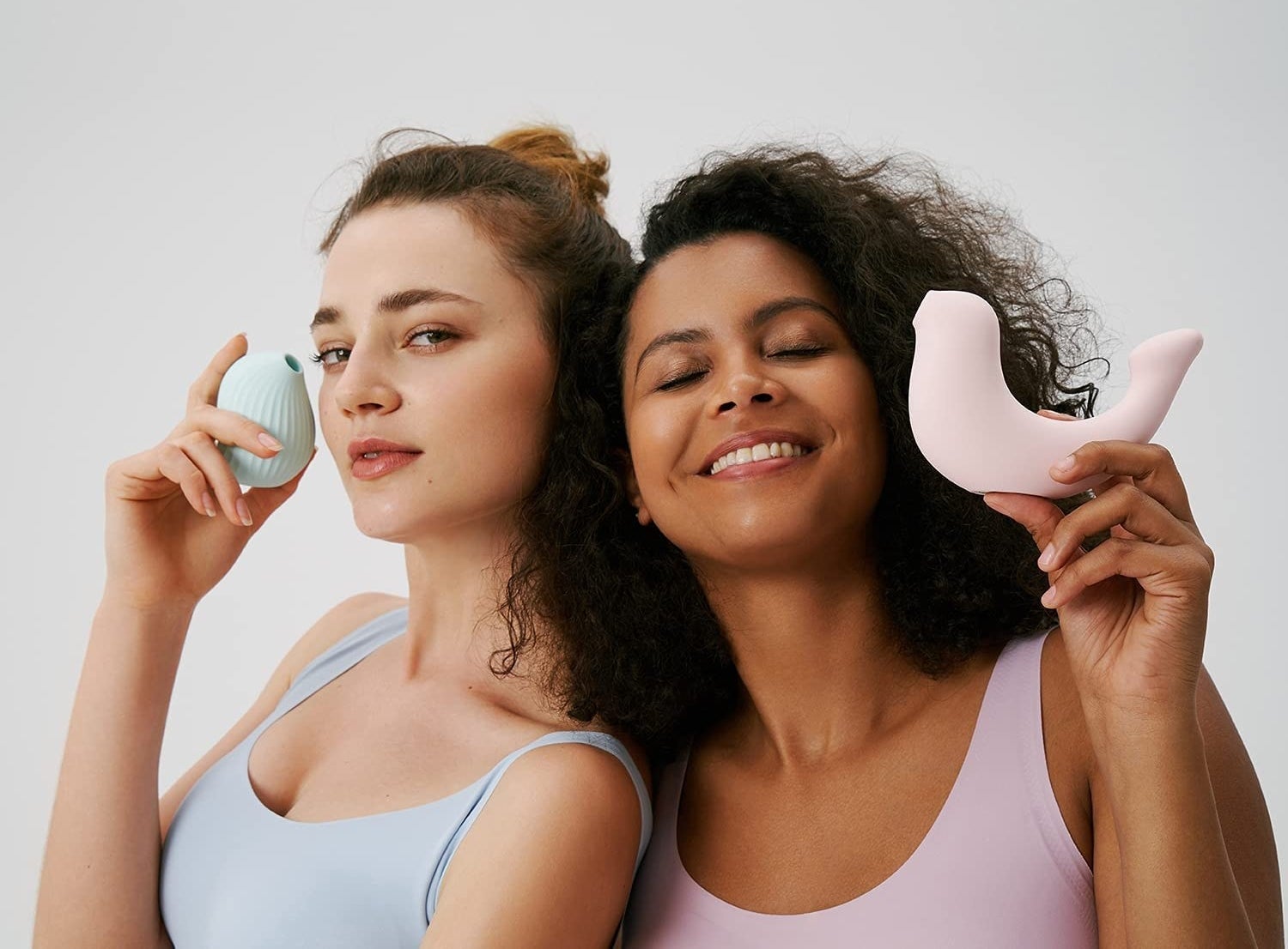 Two women holding the two different Osuga vibrators