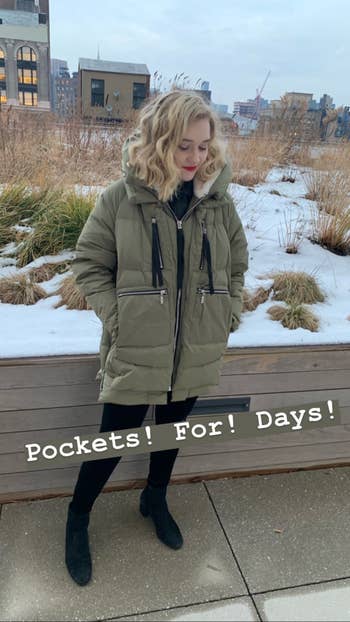 another photo of the editor wearing the coat and showing that it has big pockets