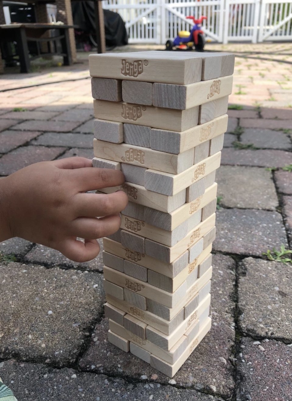 a child pulling out a jenga piece from a tower