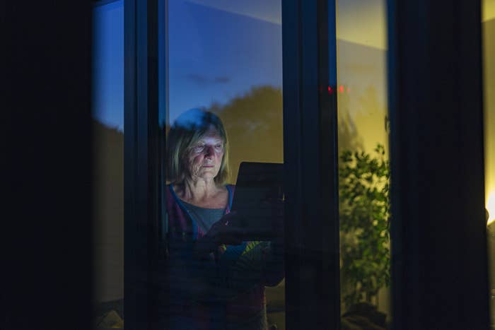 old lady looking at a computer at night