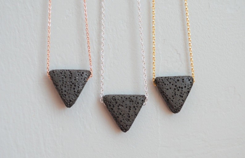 Three essential oil diffuser necklaces with rose gold, silver, and yellow gold chains