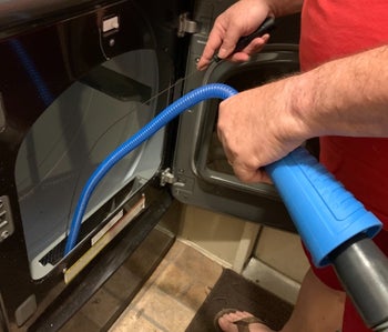 Reviewer using the dryer vent cleaner