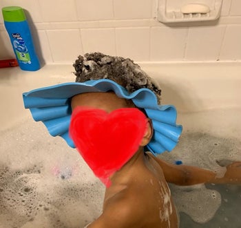 Reviewer's child wearing the blue hat in the bath