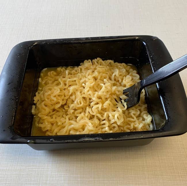 A reviewer's cooked ramen in the black rectangular bowl