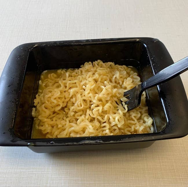 A reviewer's cooked ramen in the black rectangular bowl