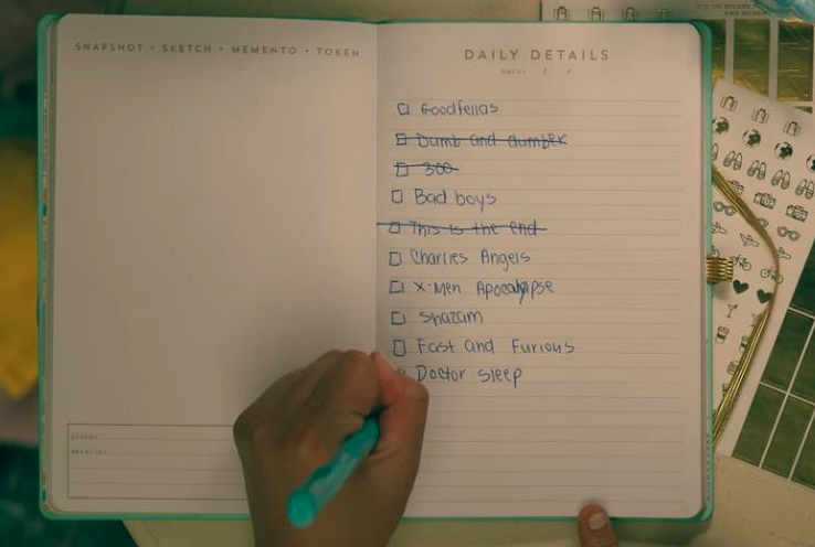 Lara Jean writing on a list of movies
