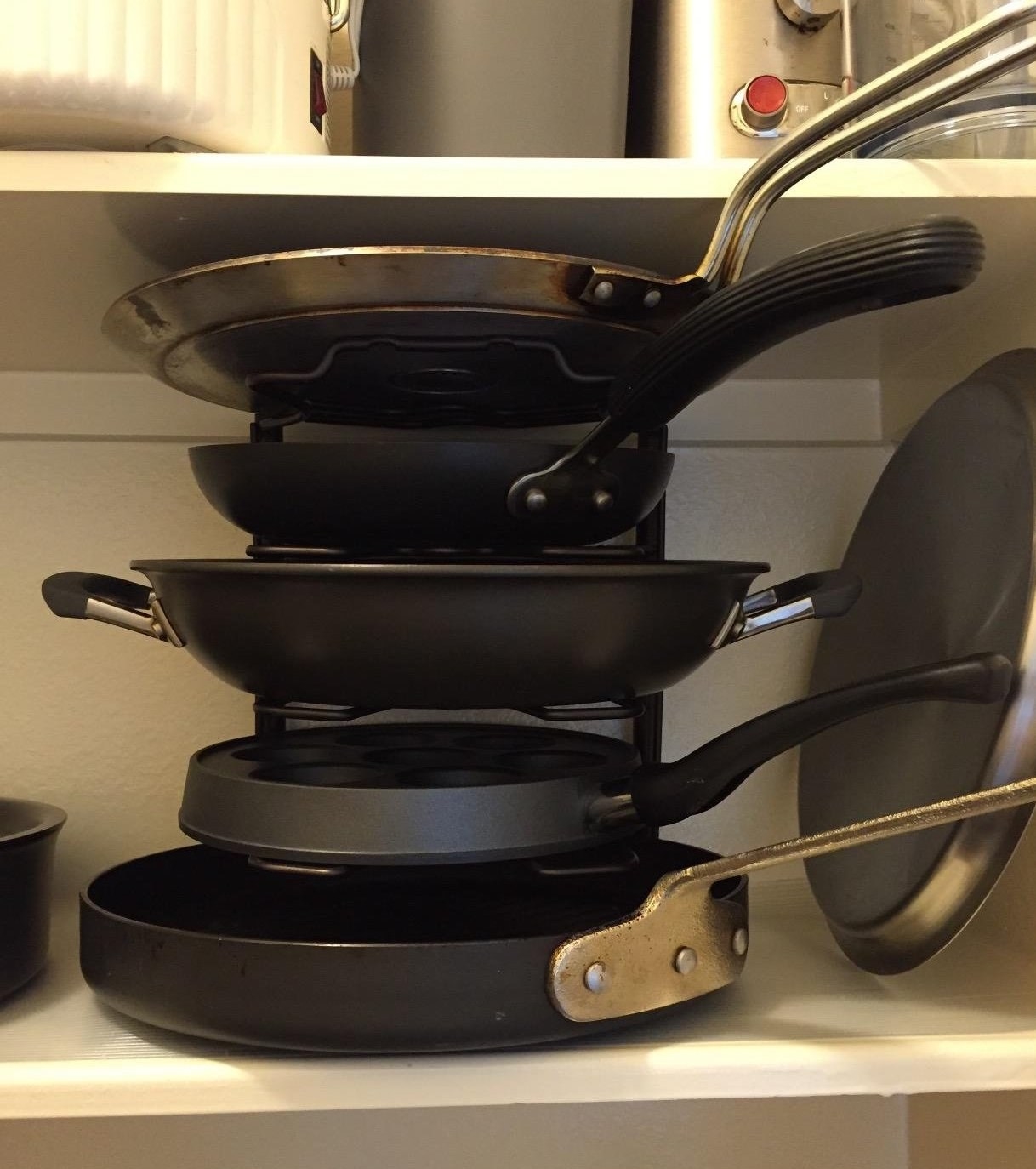 vertical rack for cooking pots and pans filled with variously sized pans