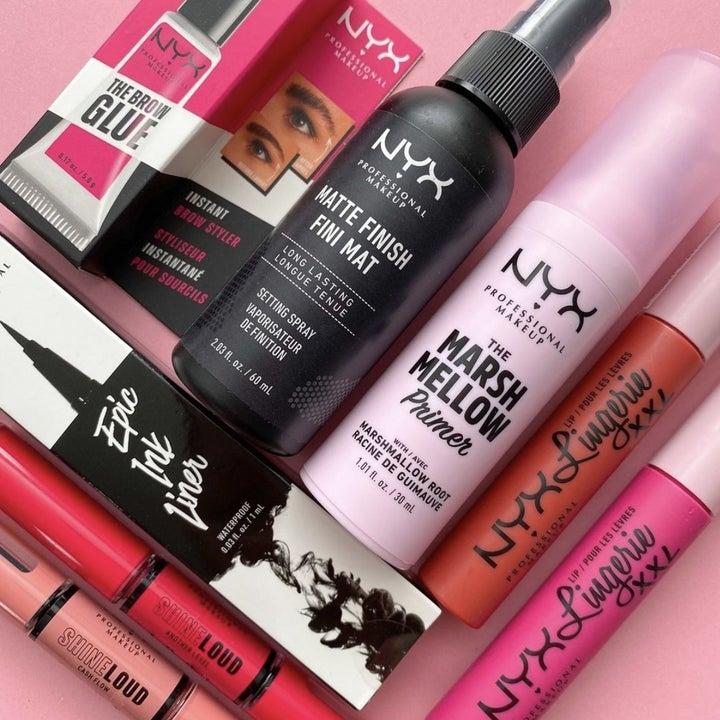 A bottle of setting spray, primer, and tubes of mascara and brow glue