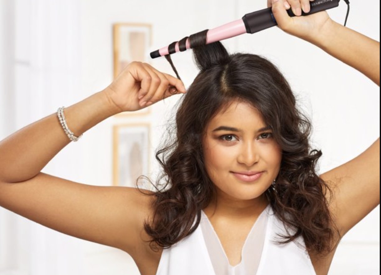 A person using a curling wand