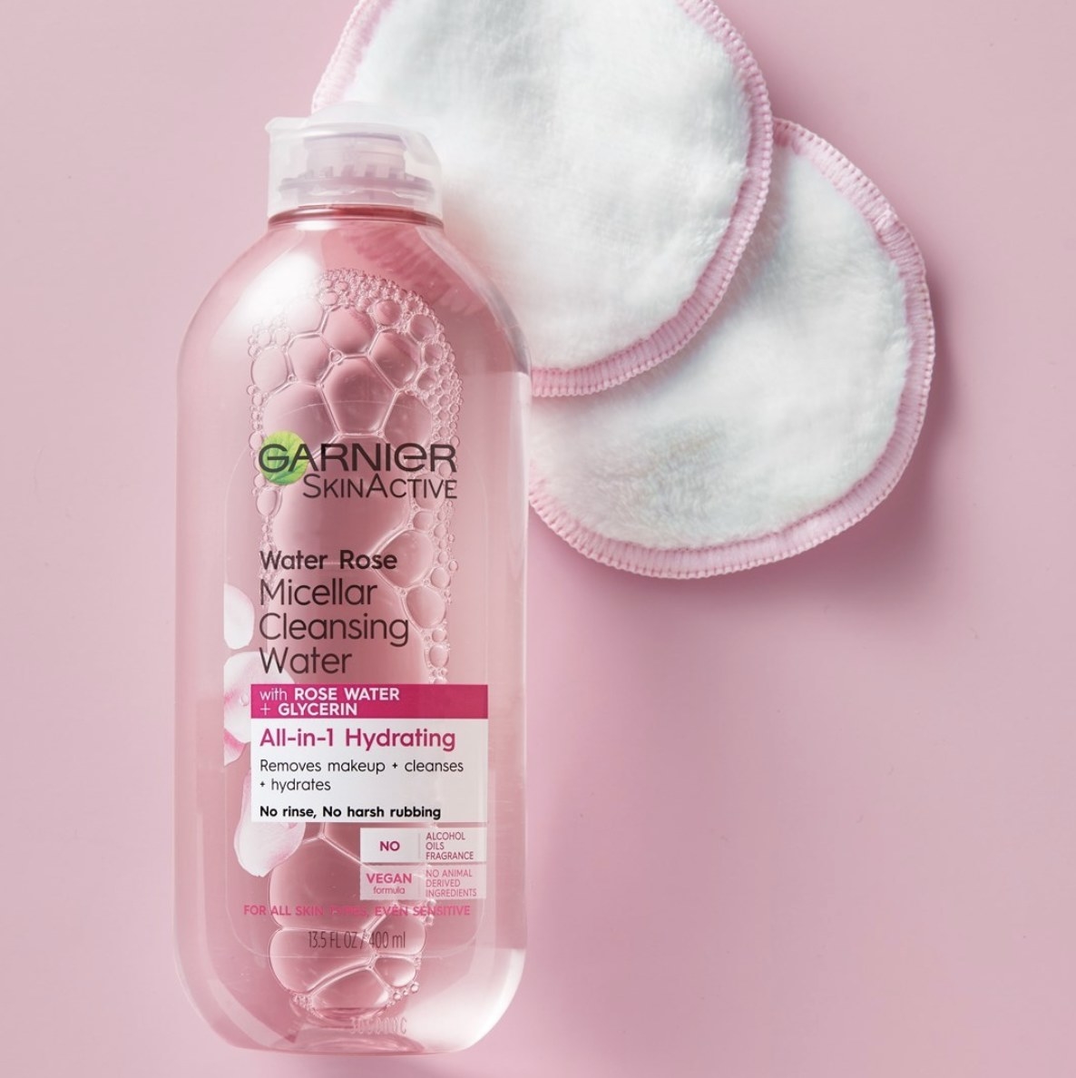 A bottle of micellar water with two cotton pads
