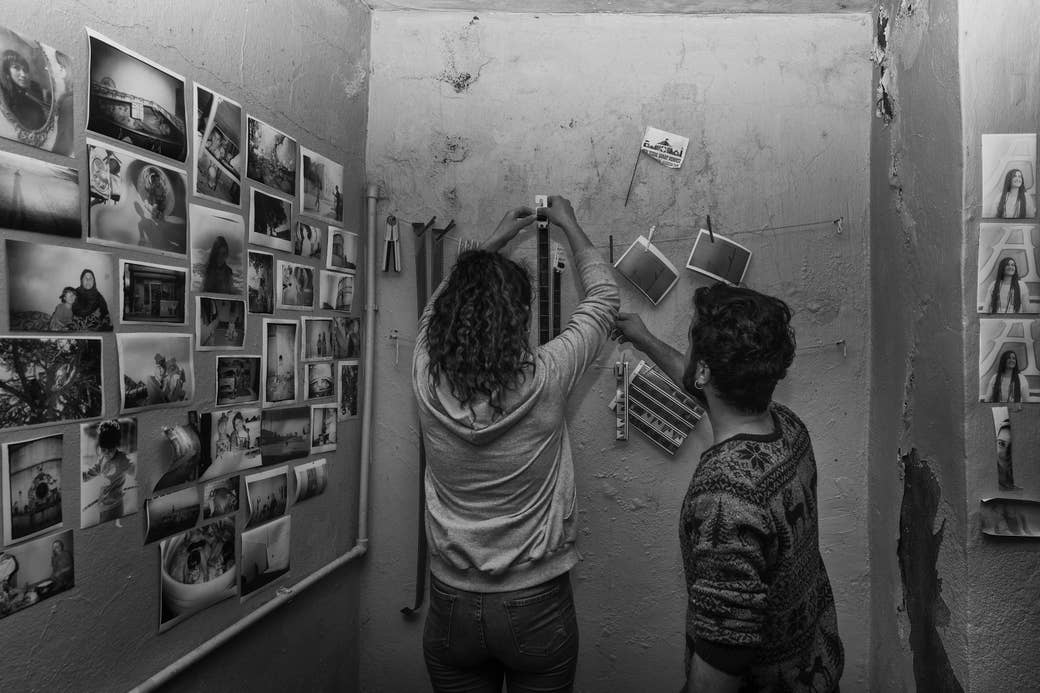 Young people hang up negatives in a darkroom
