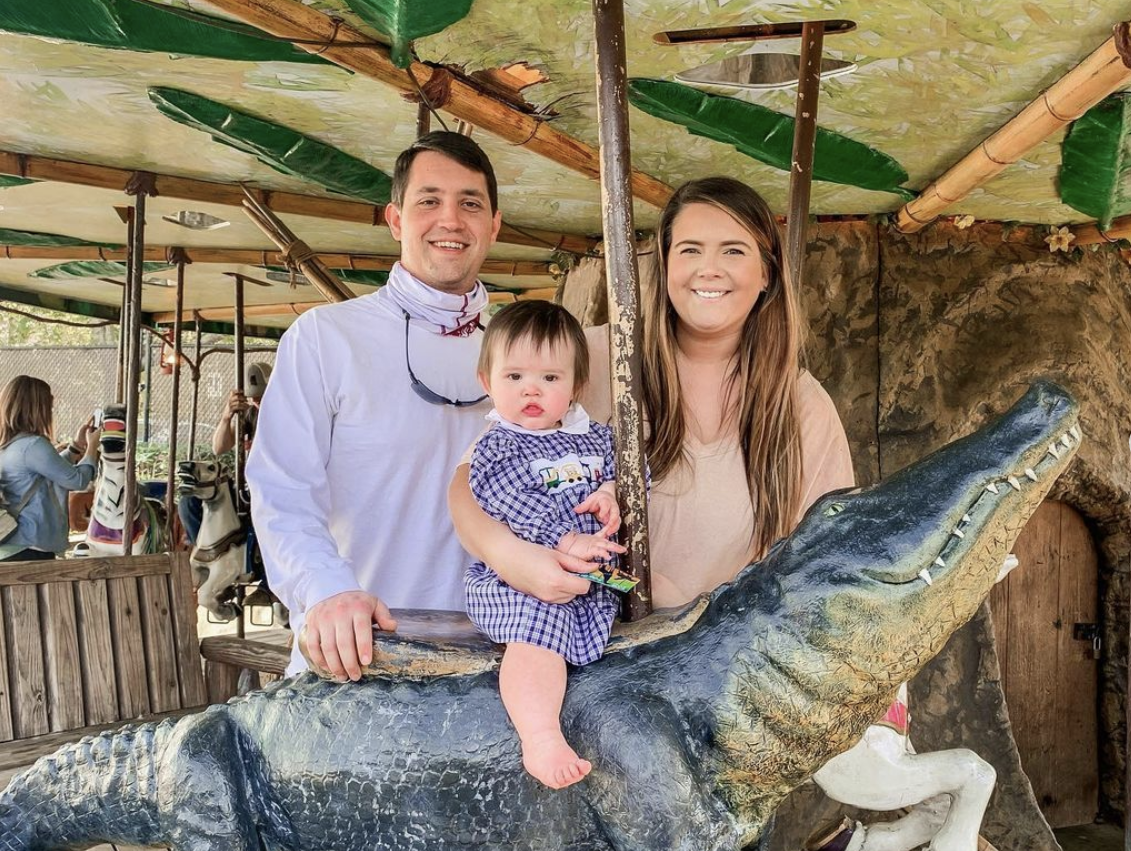 Tyler Marie on a merry-go-round with her baby riding an alligator