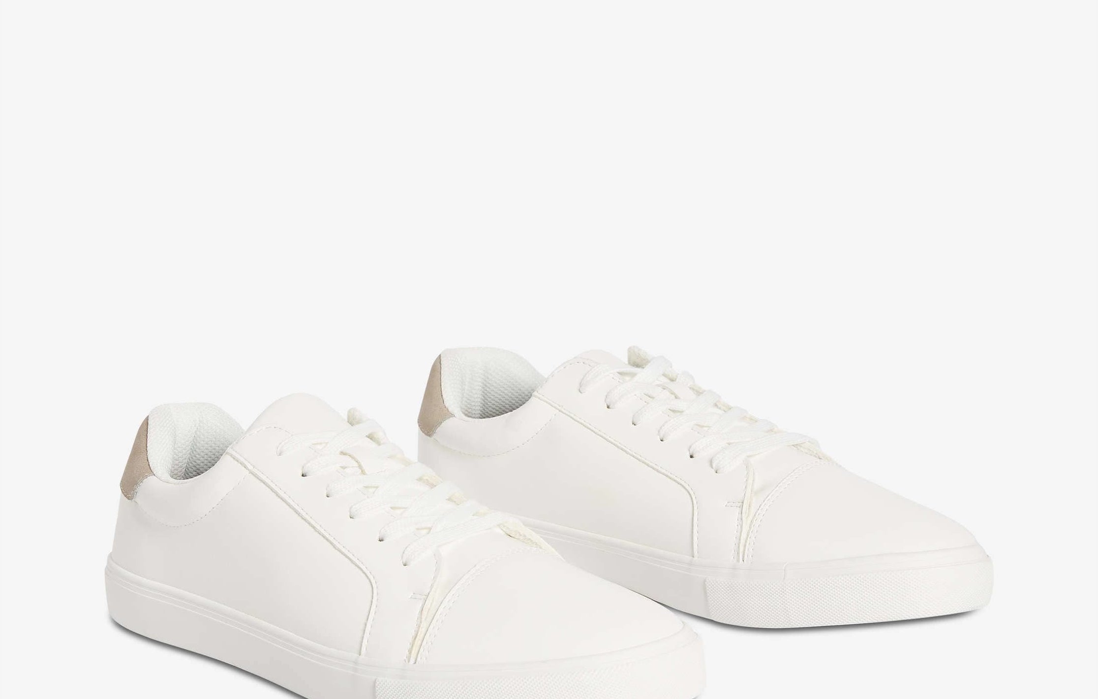 A pair of simple white sneakers on a plain background