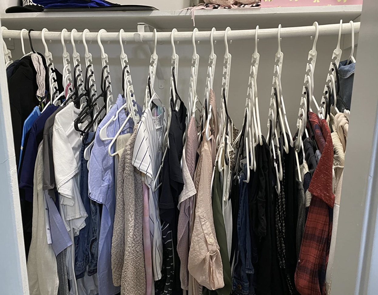 reviewer&#x27;s clothes hung vertically using the cascading hangers