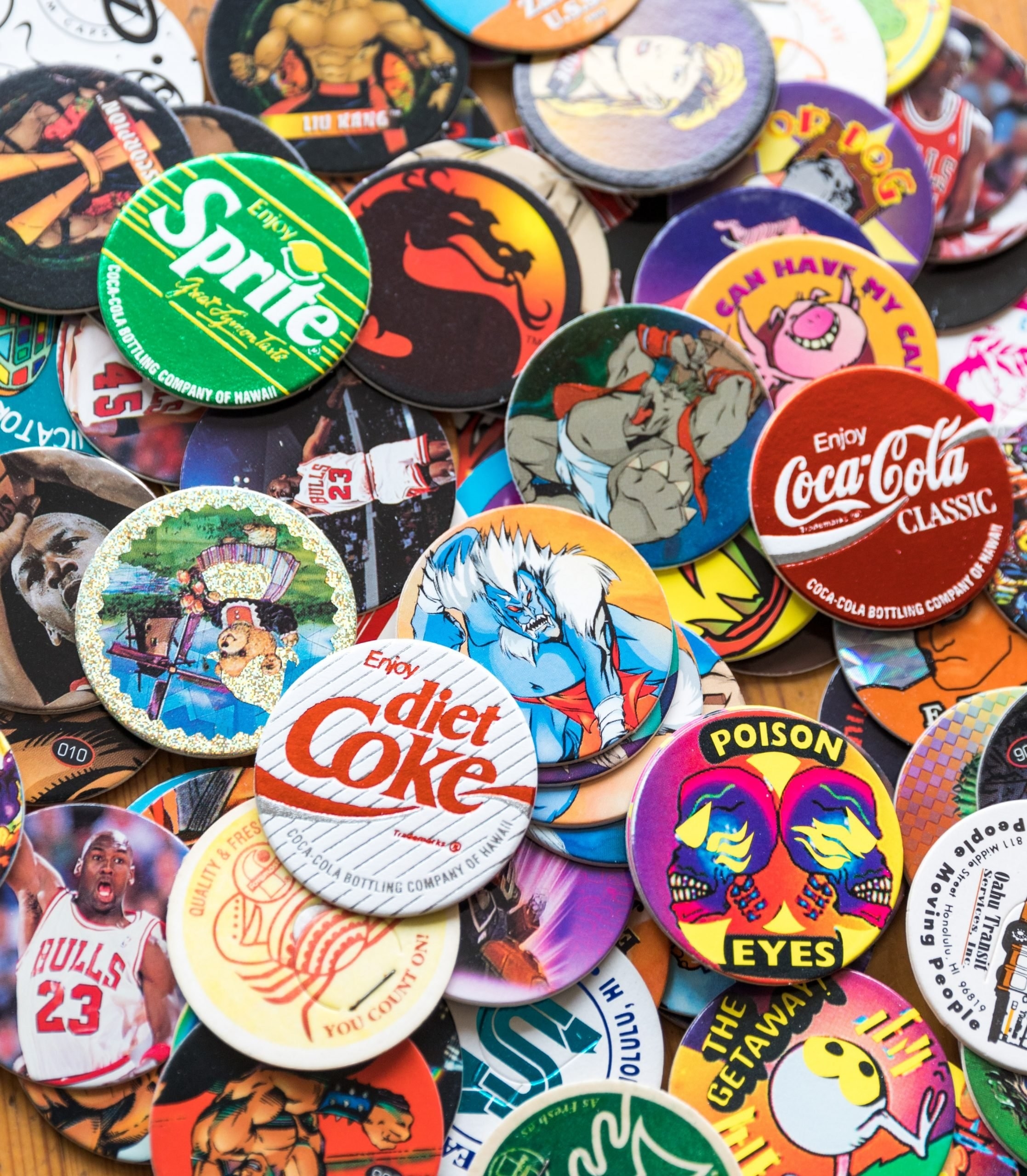 A huge pile of Pogs, including for Diet Coke, Coca-Cola Classic, Michael Jordan, and Poison Eyes