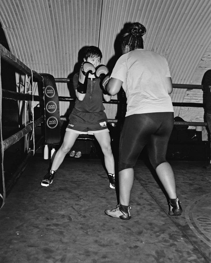 Two people facing off wearing boxing gloves