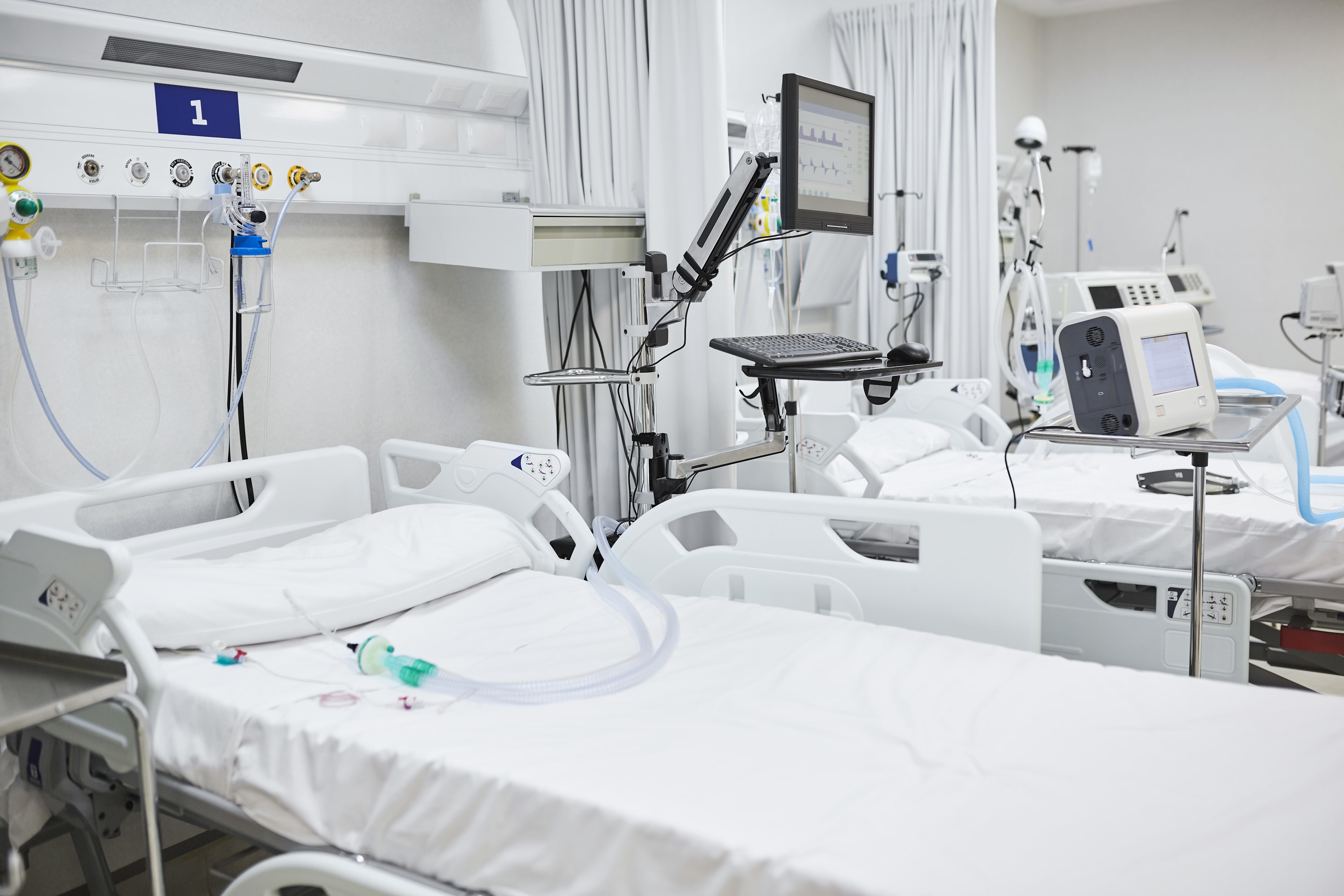 Several empty hospital beds side-side