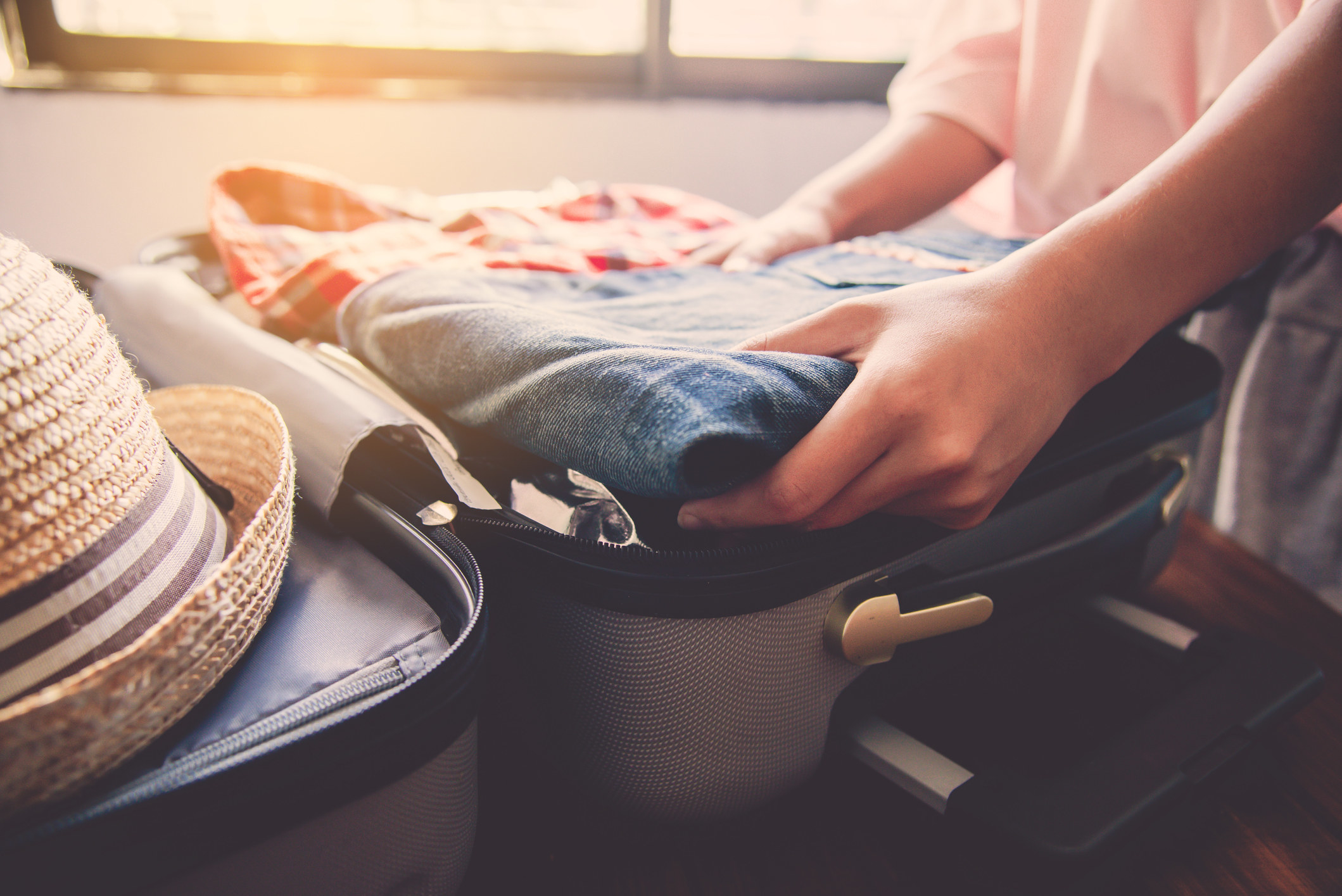 A woman packing a suitcase.