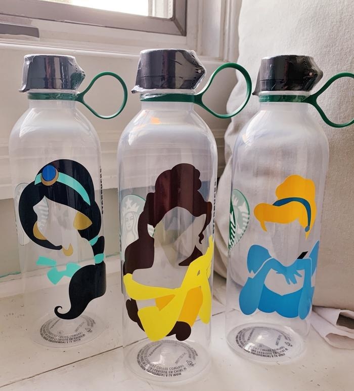 three clear water bottles with colorful yet faceless animations of jasmine, Belle, and Cinderalla respectively