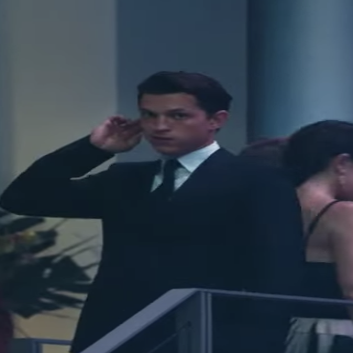 Nathan holding up his hand to his earpiece in the film