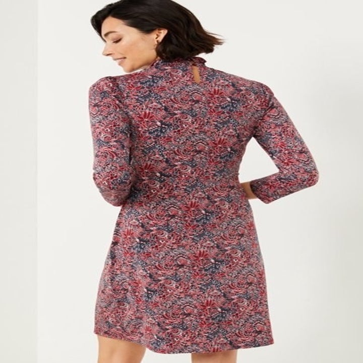 back of model wearing the dress in a paisley print