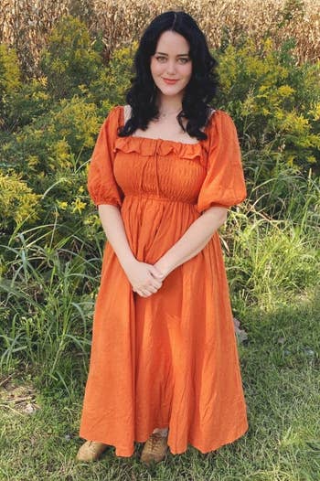 a reviewer wearing the puff sleeve maxi dress in orange