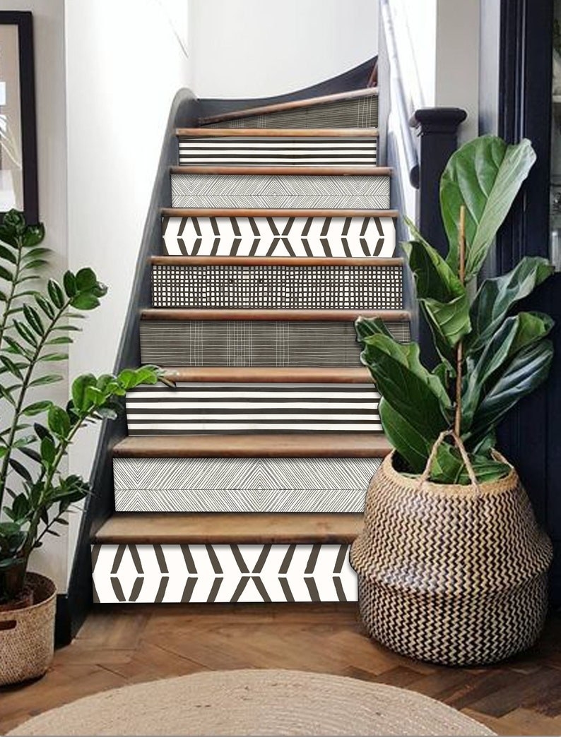 the strips on the vertical panels of a staircase in different black and white patterns
