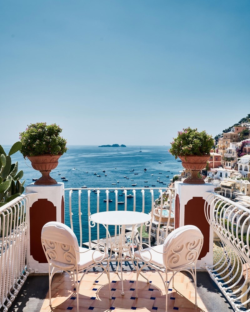 Balcony with a small table and chairs overlooking the scenery of the Amalfi Coast