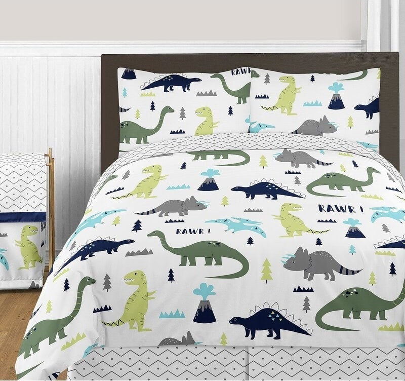 the dinosaur printed bedding on a bed