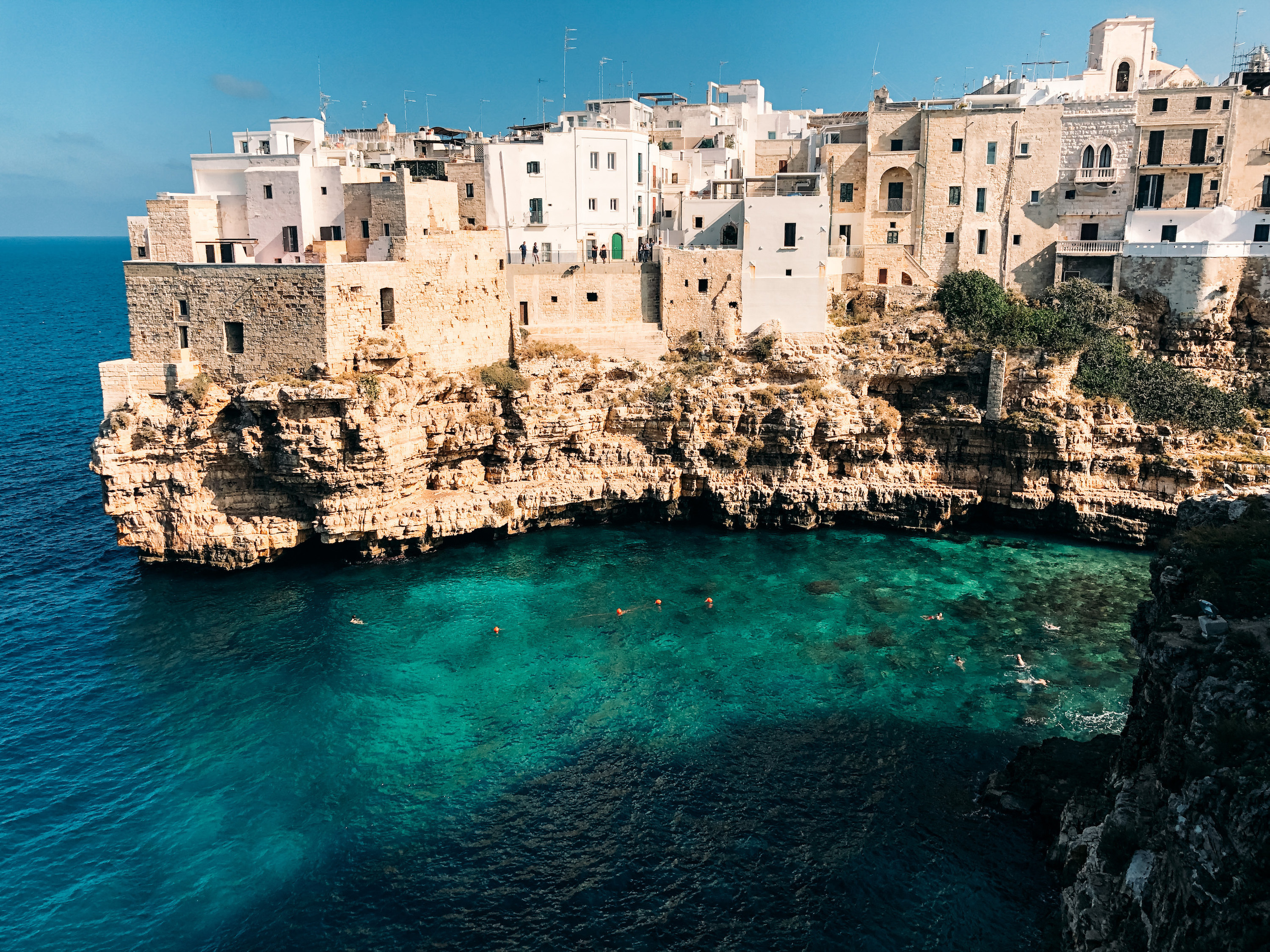 Buildings of polignano a mare built onto caves jutting out into the sea