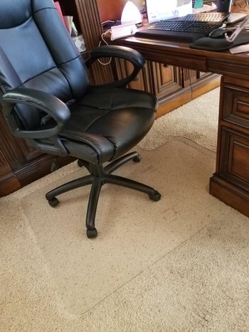 a review photo of the plastic grip on carpet with an office chair on top