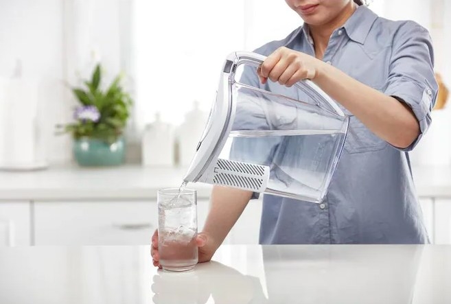 Someone pouring water through the pitcher