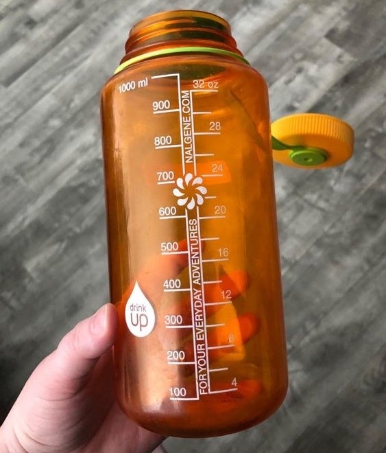 reviewer&#x27;s orange 32-ounce Nalgene with a wide screw-top lid