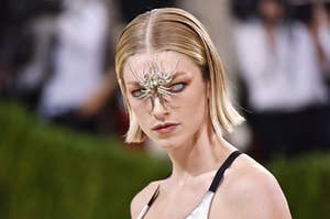Hunter Schafer wearing whiteout contacts and a spider charm in between her eyes