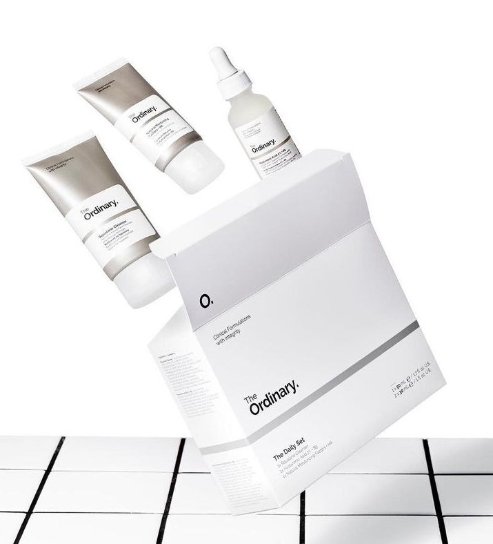 an open box of the three-piece skincare set; the pieces are seemingly flying out of the box