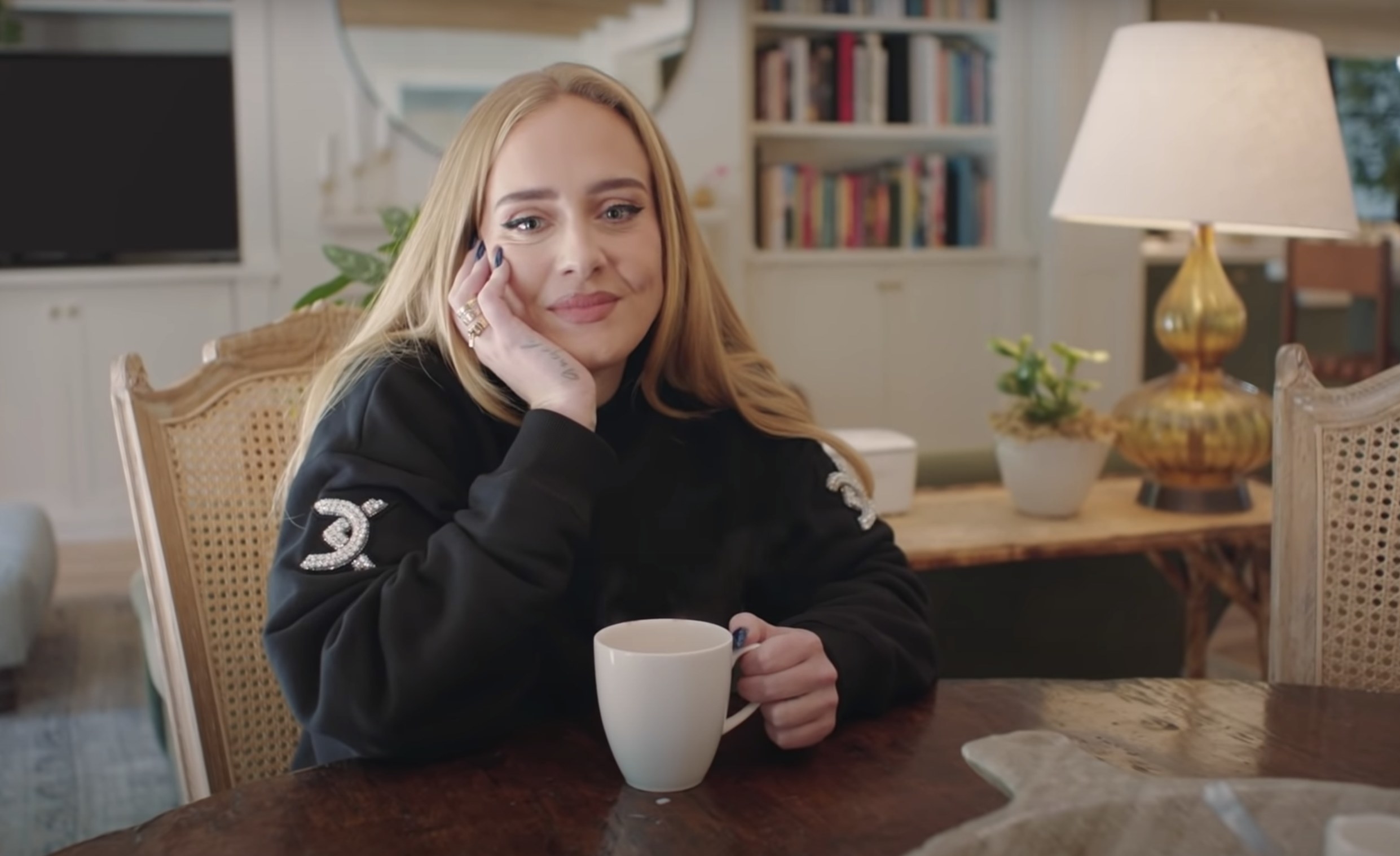 Adele sits at her dining table with a cup of tear during the interview