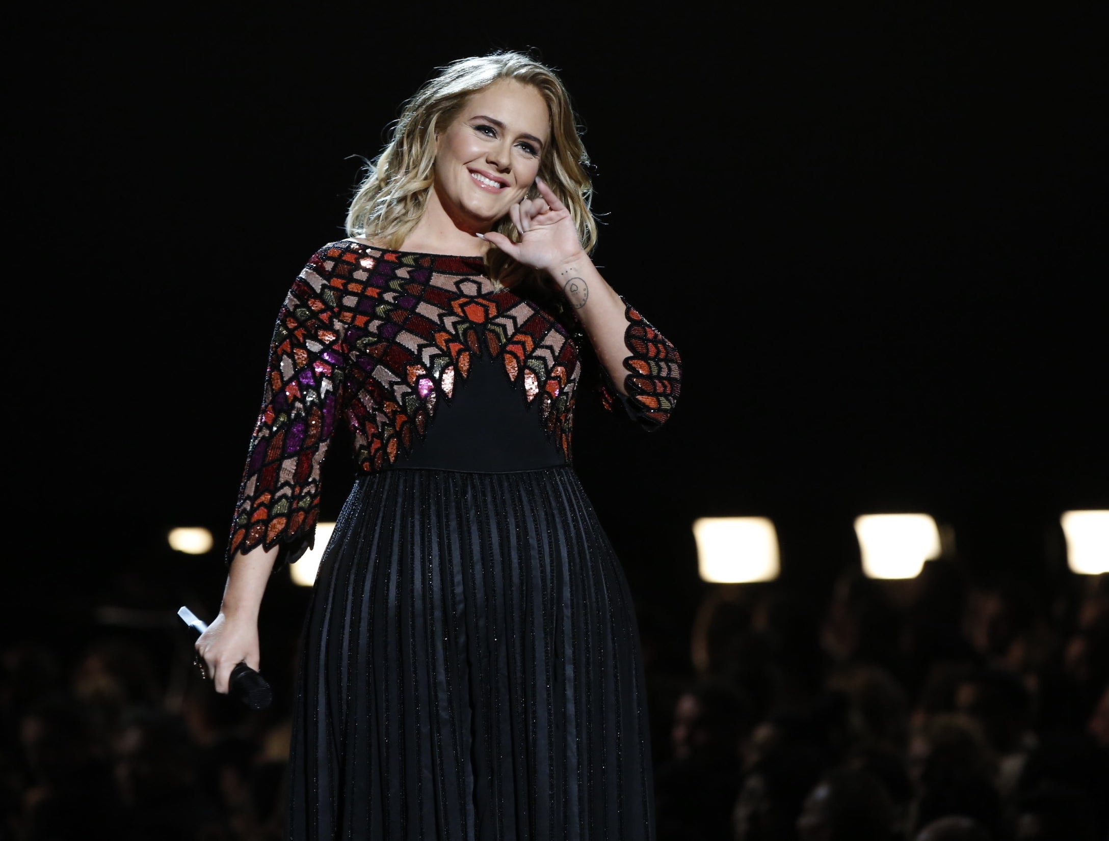 Adele smiles during a concert