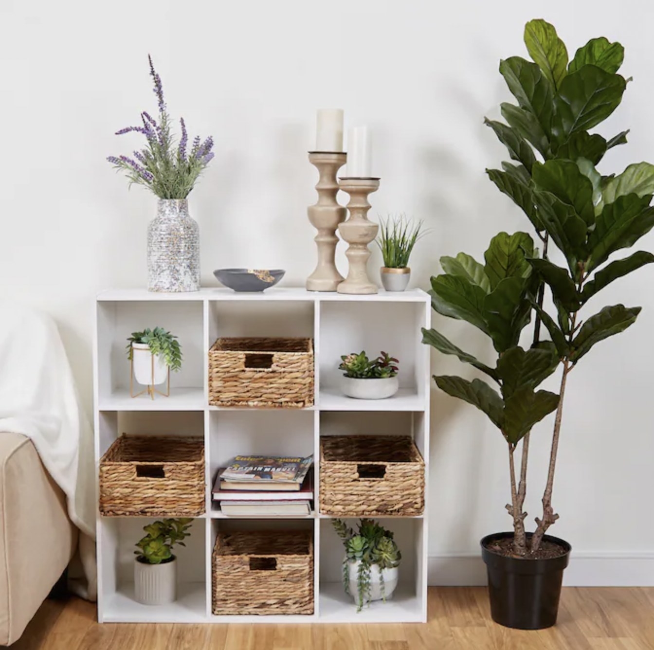 White storage cube with nine units filled with plants and wooden baskets