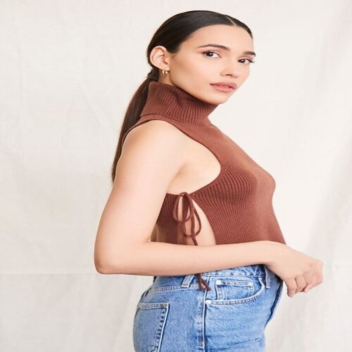 a model showing the side view and one side tie of the brown turtleneck.