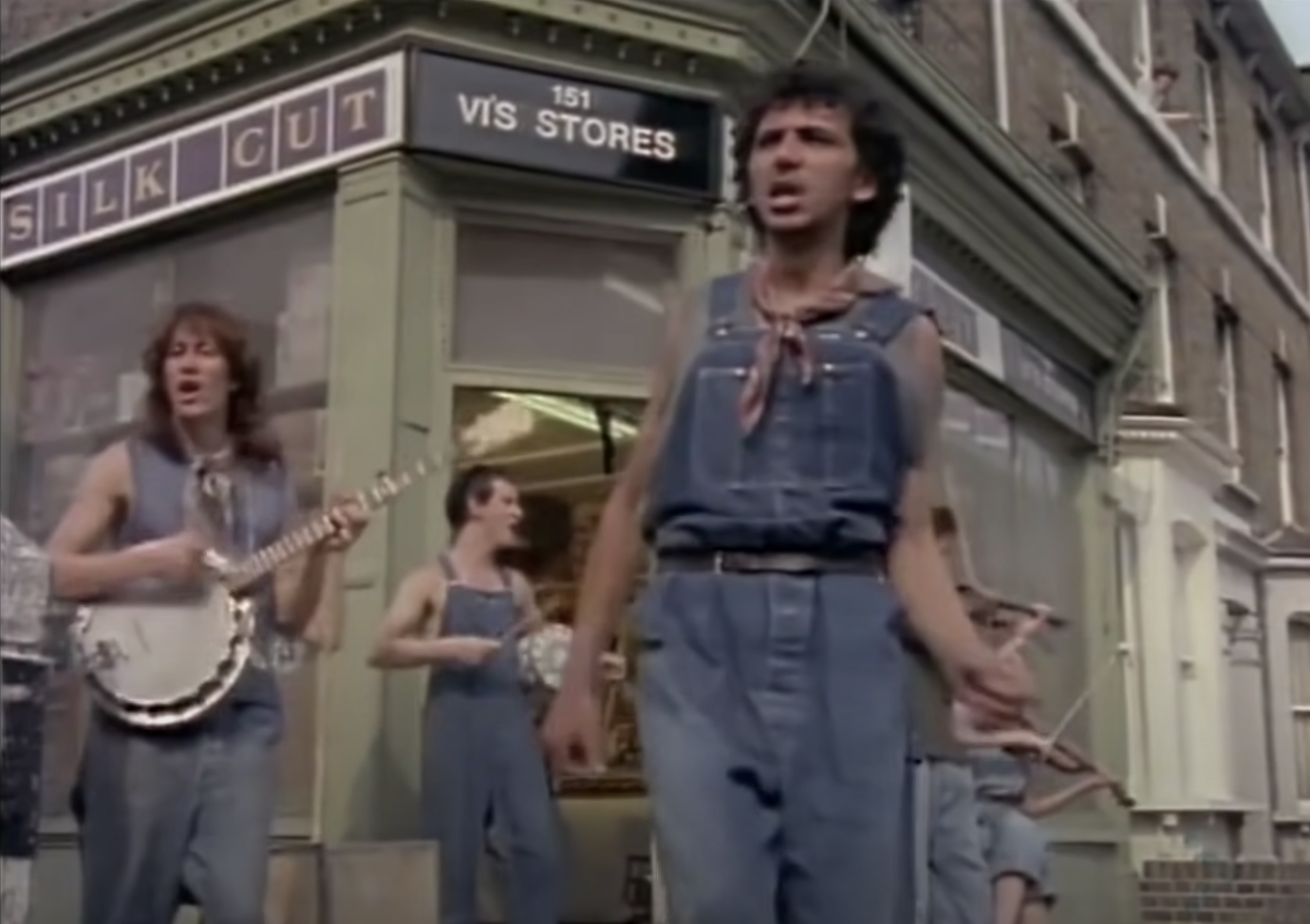 The band in earthy denim performing on banjo and violin in the video