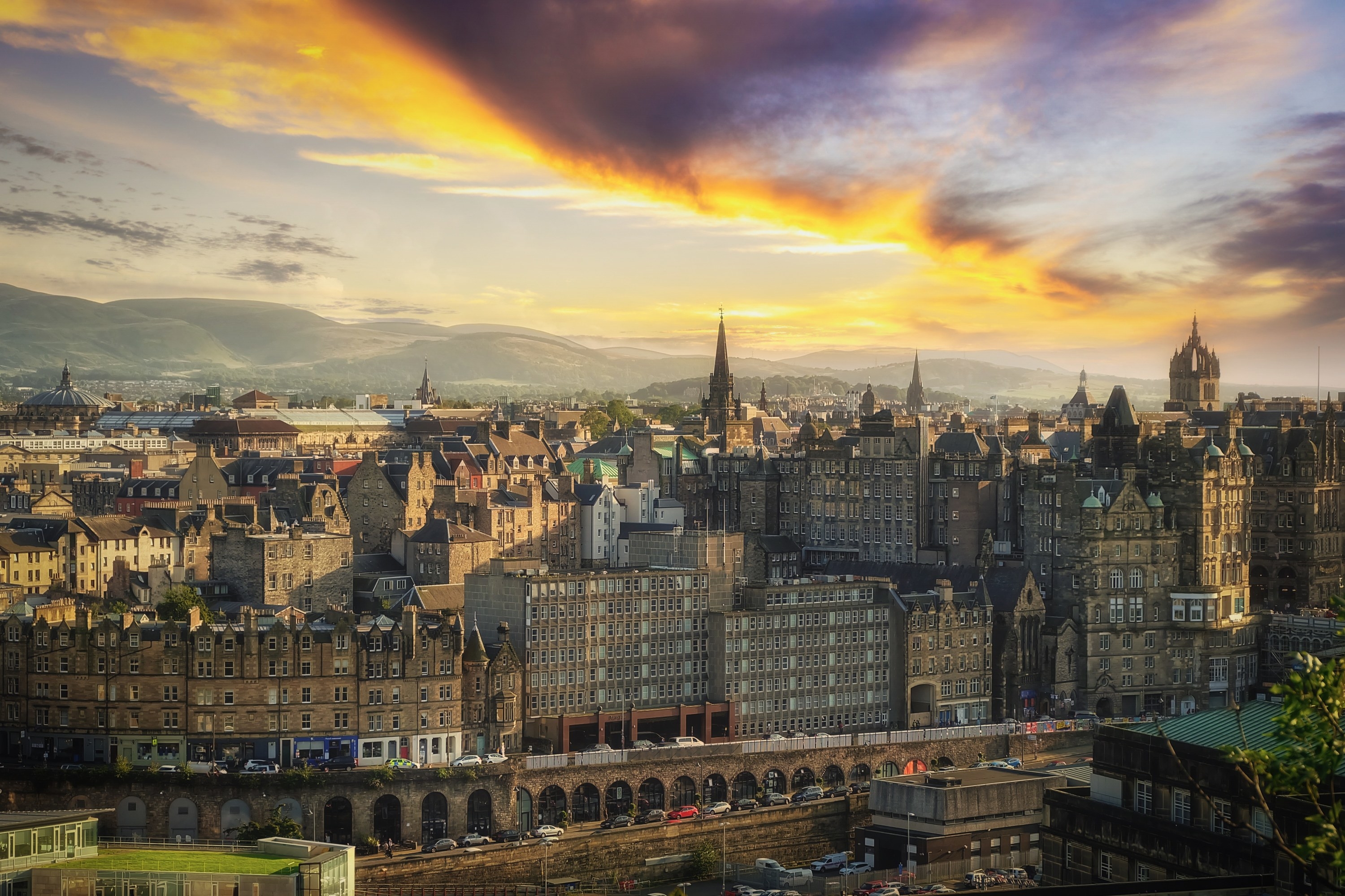 Edinburgh city under colorful sky at sunset time shows various architecture of house and building.