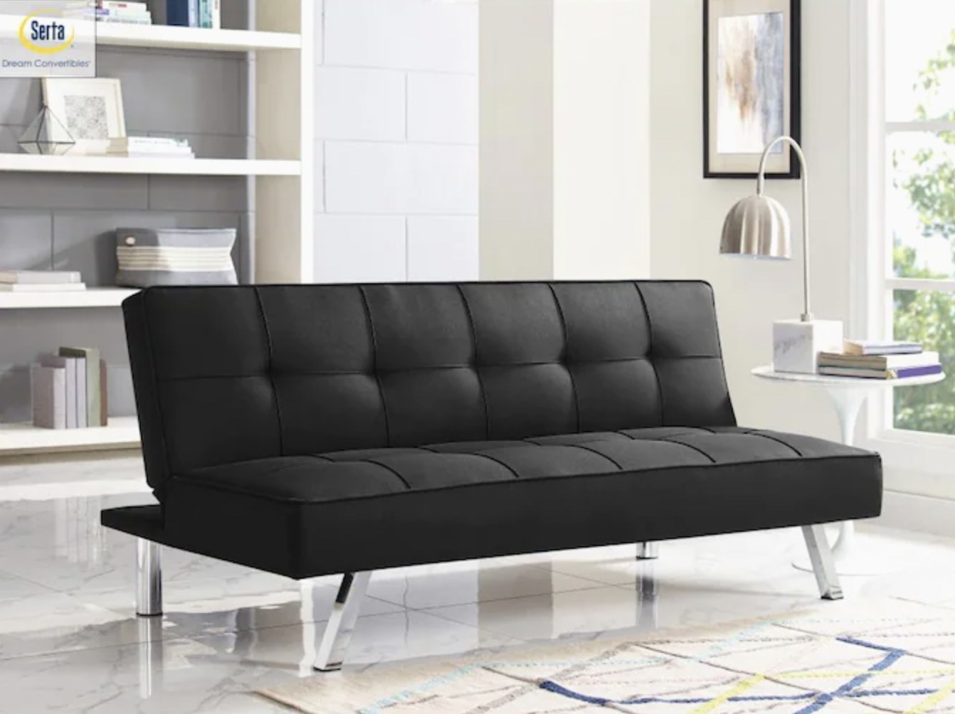 Black sofa bed propped upwards in a recline position on a white floor