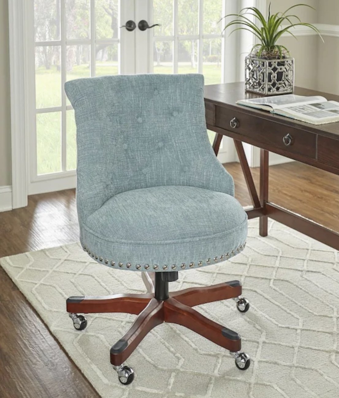 Aqua blue swivel chair with silver nail accents on wheels