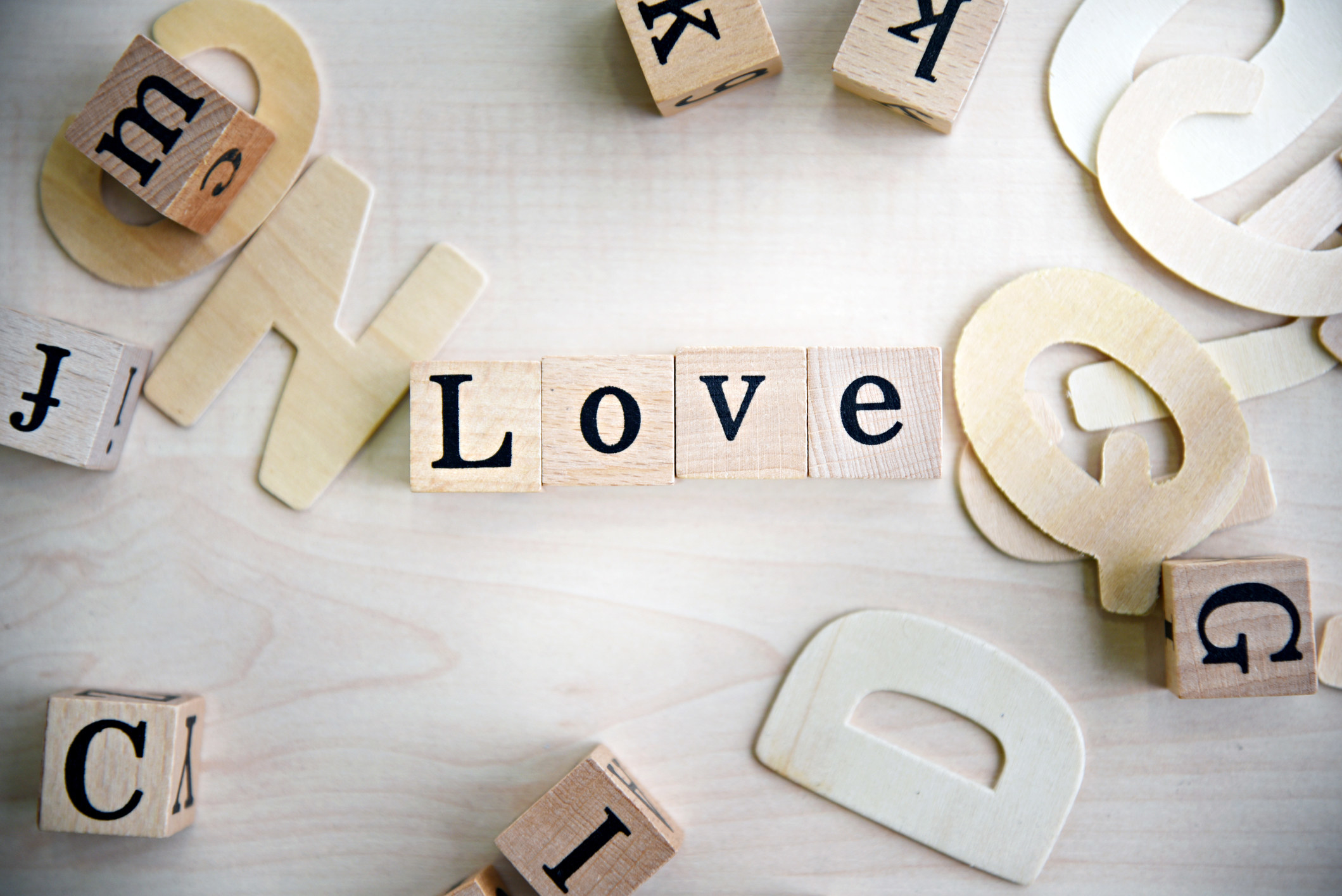 Among other blocks and letters, four tiles spell out the word love.