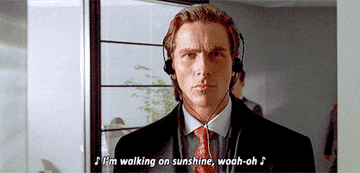 Christian Bale walking with headphones in &quot;American Psycho&quot;
