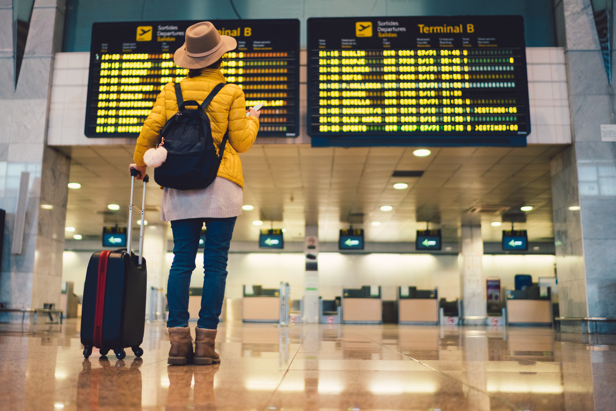 A person looking at the departure board at the airport.