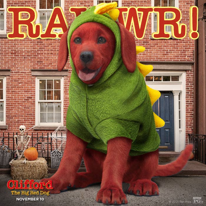 Clifford The Big Red Dog, dressed in a dinosaur costume, sits in front of a house.